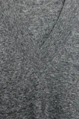 Jersey oversize color beige melange, confeccionado con lana, con cuello en V y manga larga.