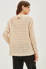 Sweater de punto con diseño calado geométrico, cuello redondo y mangas largas. Confeccionado en una mezcla de lana y alpaca, presenta una textura suave y ligera.