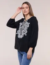 Blusa negra de silueta suelta con escote en V y elegante bordado frontal de arabescos en color blanco. Presenta mangas tres cuartos abullonadas con puños elastizados y diseño de inspiración boho.