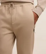 Pantalón jogger deportivo de hombre en color azul, con cintura elástica ajustable con cordón, bolsillos laterales con cierre de cremallera y bajo ajustado con puño elastizado.