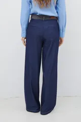 Pantalon de corte recto y pierna ancha, confeccionado en tela tipo denim color azul oscuro, con costuras a contratono y detalle de abertura lateral en el ruedo.