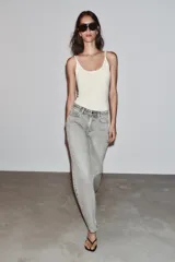 Jeans de tiro alto, pernera recta y larga, estilo clásico con cinco bolsillos, cierre frontal con cremallera y botón metálico.
