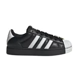 Championes adidas Superstar de plataforma, color negro con las icónicas tres tiras laterales en blanco y puntera de goma blanca. Presentan un diseño clásico con cordones negros y detalle metálico en la parte superior.