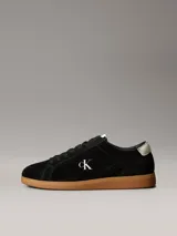 Zapatillas Calvin Klein de perfil bajo elaboradas en ante negro, con suela cupsole de goma marrón. Presentan detalles en contraste de color blanco en el talón y la lengüeta, además del monograma 'ck' bordado en el lateral.
