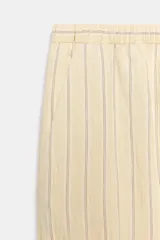 Pantalón bombacho de tiro medio, confeccionado en hilatura con mezcla de viscosa, con estampado de rayas verticales en tonos beige y amarillo claro, cintura elástica ajustable con cordón y puños en los tobillos.