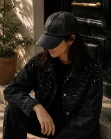 Gorra de cuerina negra, de diseño clásico y visera curva.