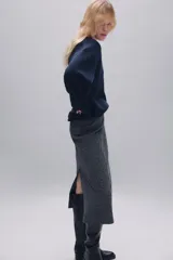 Jersey de punto liso confeccionado en lana 100%, con cuello en pico y manga larga. Presenta acabados en rib en puños y bajo.