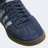 Championes Adidas Handball Spezial, color azul marino con detalles en celeste y suela marrón. Confeccionados en gamuza con las tres tiras clásicas de Adidas en los laterales y el nombre del modelo en dorado.