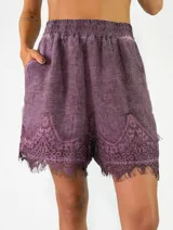 Short de lino color violeta con detalles de encaje bordado en el ruedo.