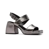 Sandalias de cuero color peltre, con plataforma y taco cuadrado. Presentan dos tiras anchas sobre el empeine y pulsera con hebilla al tobillo.