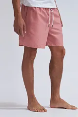 Short de baño color rosado con cintura elástica y cordón ajustable.