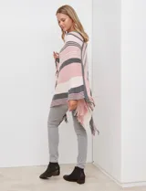 Poncho de tejido de punto, marca Barrington, con diseño de rayas diagonales en tonos rosado, blanco crema y gris oscuro. Presenta cuello en V y terminación con flecos en el ruedo.