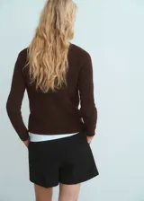 Sweater de punto fino color marrón chocolate, con cuello asimétrico, cierre lateral con botones y manga larga.