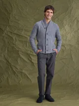 Cardigan de punto gris con cuello tipo chal y cierre frontal de botones. Presenta puños y ruedo acanalados, ofreciendo un diseño clásico y versátil.