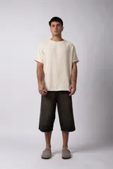 Remera de corte regular confeccionada en una mezcla de rayón y lino con textura entramada. Presenta cuello redondo, mangas cortas y un diseño de inspiración rústica y liviana.