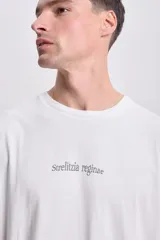Remera de corte oversize color blanco, con cuello redondo y estampa tipográfica minimalista en el centro del pecho.