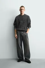Sweater relaxed fit de canalé, color negro con efecto lavado, cuello redondo y manga larga con acabados en rib.