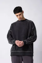 Buzo de cuello redondo con efecto lavado, corte oversize y costuras expuestas en color contrastante.