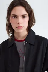 Campera bomber color beige con cuello solapa, confeccionada en 100% algodón, con cierre frontal con cremallera y acabado elástico en el bajo.