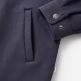 Camisa azul marino de micropolar con cuello clásico, cierre frontal con botones a presión, dos bolsillos de parche en el pecho y puños abotonados.