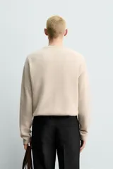 Jersey de punto canalé con cuello redondo y manga larga, confeccionado en hilatura de cashmere. Presenta un corte regular fit con acabados en rib en puños y bajo.