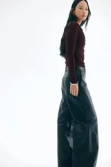 Top ajustado de manga larga, color borgoña oscuro, confeccionado en tejido elástico y semitransparente, con escote tipo cascada o drapeado.