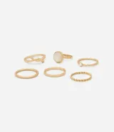 Set de seis anillos dorados con diferentes diseños y texturas, algunos con detalle de perla.