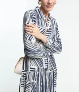 Vestido chemise midi de viscosa con estampado abstracto en tonos azul y blanco. Tiene cuello solapa y cierre frontal con botones.