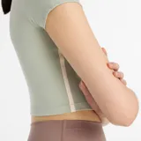 Remera deportiva New Balance modelo Harmony Fitted, color verde claro, de corte ajustado y largo crop. Presenta mangas cortas, cuello redondo y logo de la marca en el pecho.