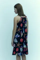 Vestido corto con escote halter y estampado de motivos marinos multicolores sobre fondo azul marino.