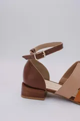 Sandalias de cuero color marrón, con combinaciones de color beige y naranja. Tiene tira ajustable con hebilla en el tobillo y taco bajo.