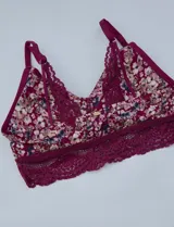 Pack de dos bralettes de encaje marca Jessica Simpson. Uno es de encaje negro y el otro es estampado floral con base borgoña y breteles fijos.