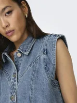 Chaleco largo de denim azul con cuello camisero, cierre frontal de botones metálicos, bolsillos frontales aplicados y costuras pespunteadas visibles.