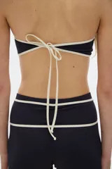 Minishort negro con cintura alta y cordones cruzados blancos.