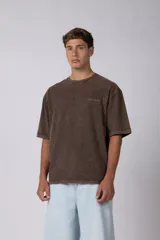 Remera de algodón gris con efecto acid wash, corte regular, mangas cortas y cuello redondo. Cuenta con un pequeño bordado tono sobre tono en el pecho y una etiqueta lateral distintiva de la marca en el ruedo.