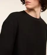 Remera color crema, de corte holgado, con cuello redondo y mangas cortas.