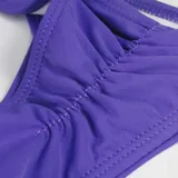 Bombacha de bikini tipo colaless con diseño plisado en el centro, confeccionada en tejido elástico.