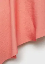 Top strapless color rosado, con diseño entallado y bajo asimétrico con vuelo. Presenta panel fruncido elástico en la parte posterior.