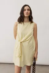 Vestido corto blanco sin mangas, con cuello redondo y detalle de nudo drapeado en el lateral.