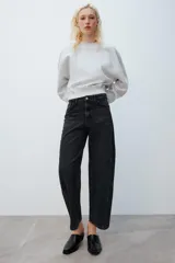 Jeans de tiro medio con diseño de volumen crop y perneras curvas. Presenta cinco bolsillos, cierre frontal con cremallera y botón metálico.