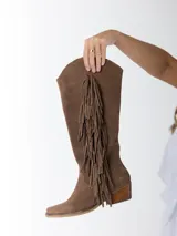 Botas texanas de caña alta color marrón, confeccionadas en gamuza con flecos laterales y taco de madera.