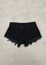 Short de jean negro de tiro bajo con diseño desflecado en los bordes inferiores, bolsillos delanteros y traseros, y cierre frontal con botón y cremallera.