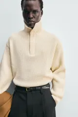Jersey de punto con cuello perkins y cierre frontal con solapa oculta. Presenta diseño de manga larga con terminaciones en rib.