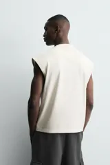 Camiseta sin mangas tipo tank con corte boxy fit, confeccionada en tejido técnico de algodón con elasticidad, cuello redondo y sisas amplias.