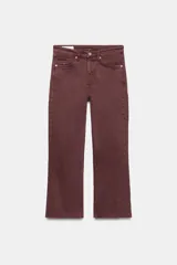 Jeans de tiro alto y diseño cropped flare color bordó, con cinco bolsillos, cierre frontal con cremallera y botón metálico, y bajo sin costuras.