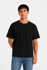 Remera manga corta de algodón de corte holgado y cuello redondo, color negro, con pequeño texto estampado en el centro del pecho.