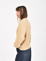 Buzo de tejido de punto grueso en color verde, con cuello redondo, mangas largas y corte holgado.