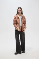 Campera acolchada de poliamida en color beige, con diseño de costuras en rombos, cuello alto, cierre frontal y bolsillos delanteros con solapa.