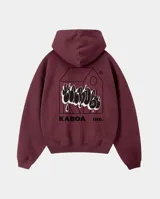 Canguro bordó con capucha, de corte regular y ajuste cómodo. Presenta un estampado gráfico en la espalda que combina una silueta de casa con letras estilo graffiti y el logo de la marca.