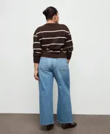 Jeans de corte wide leg con tiro medio, confeccionados en denim azul con acabado lavado y ruedo desflecado.